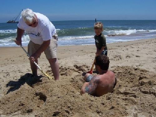 Grandpa and Cole burying Christian at the beach